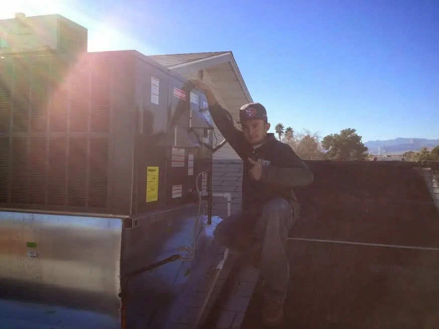 HVAC technician performing AC Tune-Up on a rooftop unit in Twentynine Palms